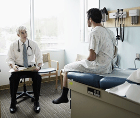 A physician and patient have a discussion in an exam room.