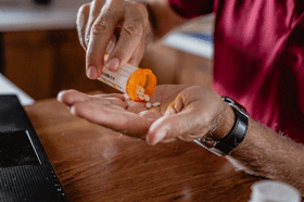 A medical provider dispenses pill into their hand