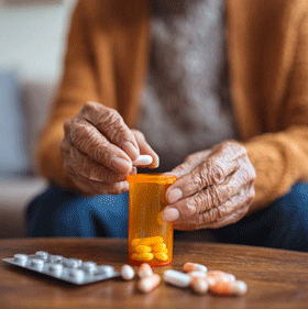  An elderly person opening prescription medication